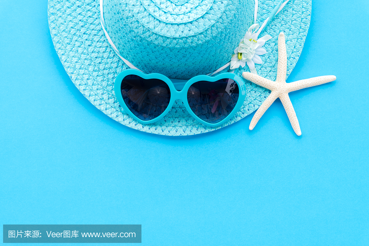 海滩配件,包括海星,蓝色太阳镜和深蓝色纸背景