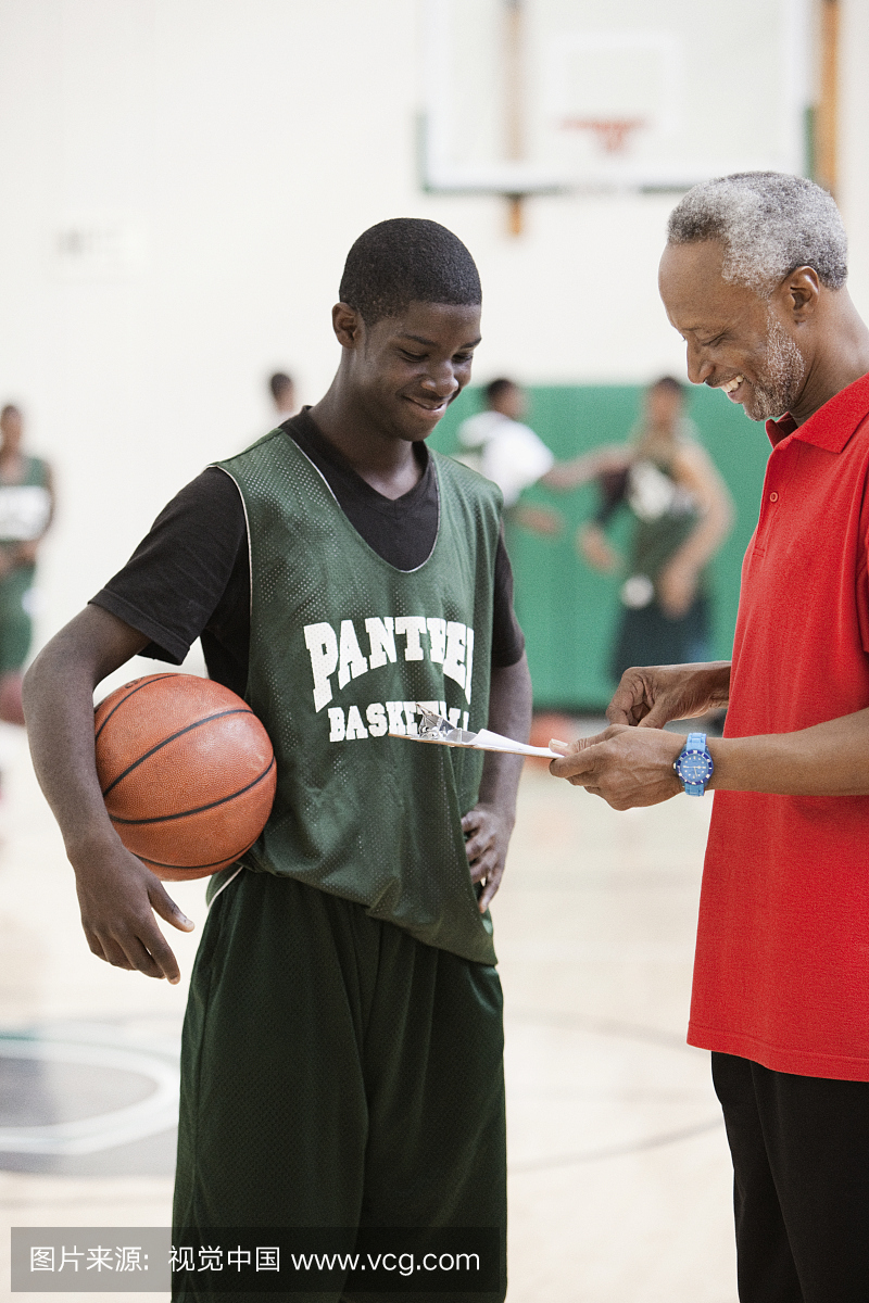非洲教练和篮球运动员在健身房进行评估