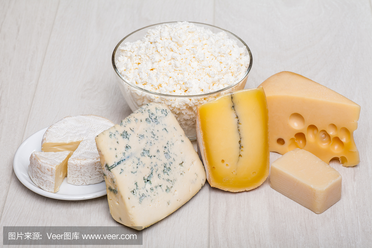 乳制品 - 木制背景上的不同种类的奶酪
