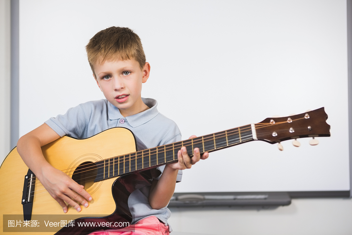 小学生在教室里弹吉他的肖像