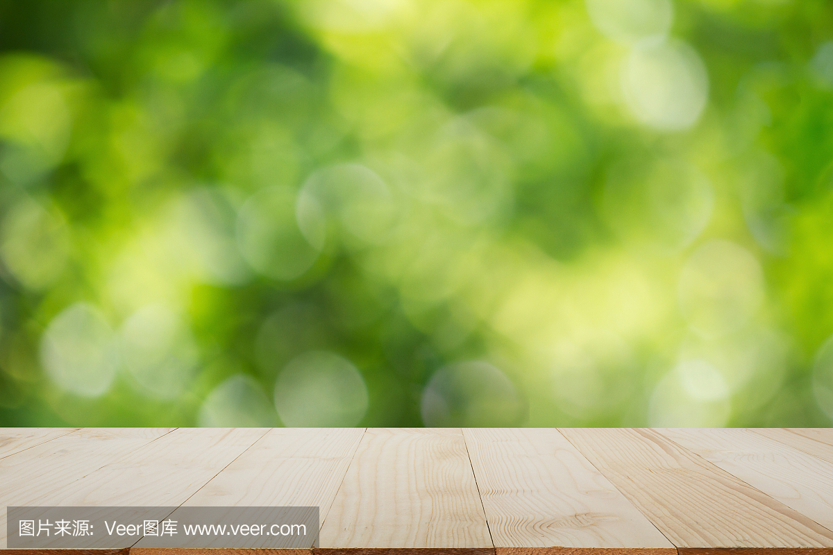 木制的桌面上模糊的绿色散景背景