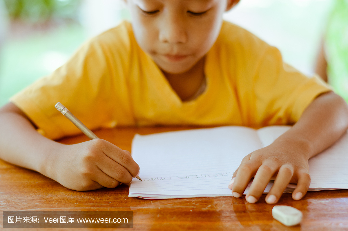 亚洲男孩写英文字母。