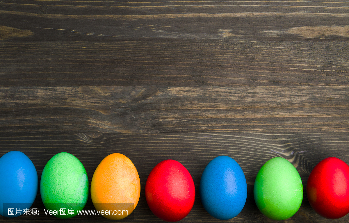 在木背景上的复活节彩蛋。不同颜色的主食蛋