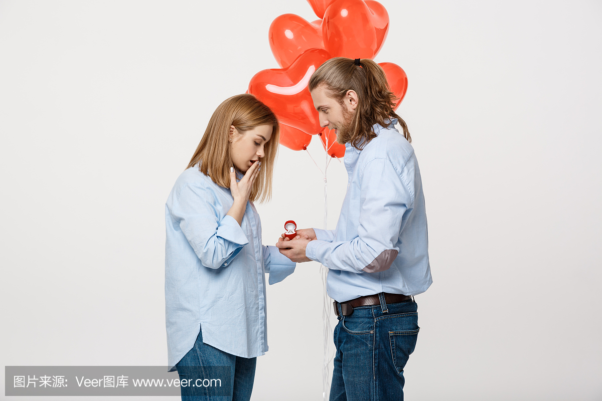 年轻帅哥的肖像给一个女孩带着红色的心形气球