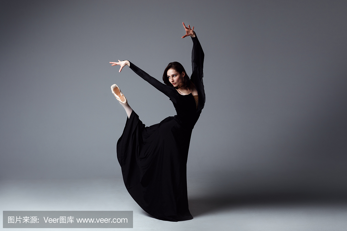 黑色长裙的苗条芭蕾舞演员在photostudio中呈
