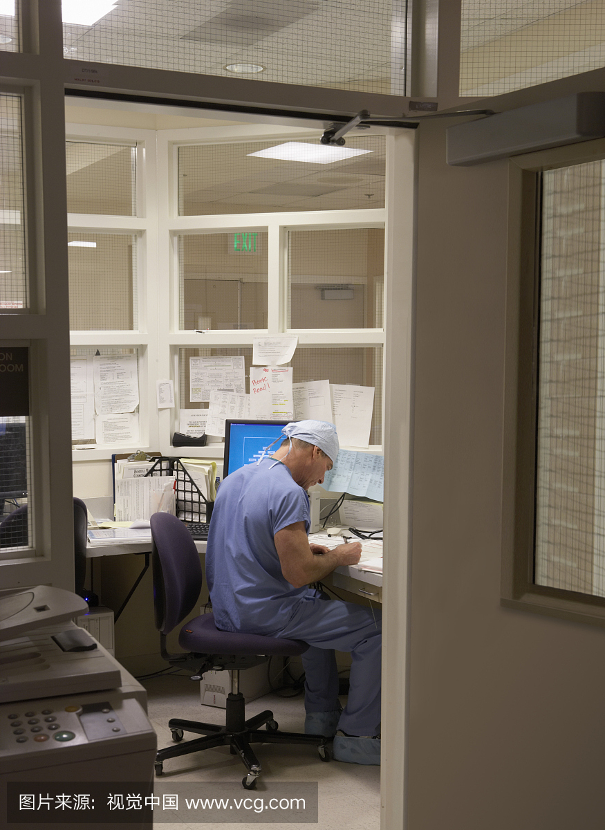 高级男急诊室医生在办公室工作,夜班