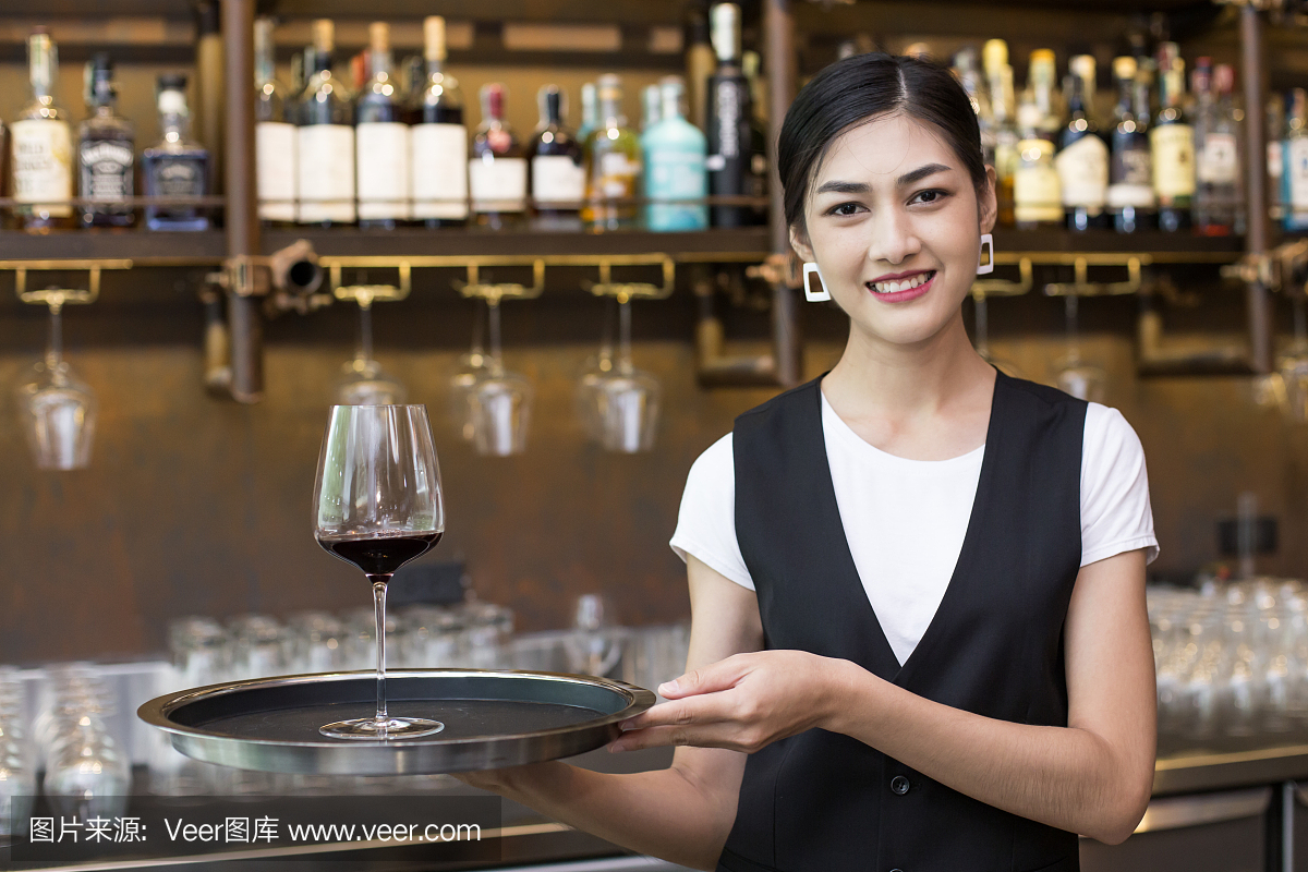 年轻的亚洲女人服务员餐厅餐饮服务快乐的情感