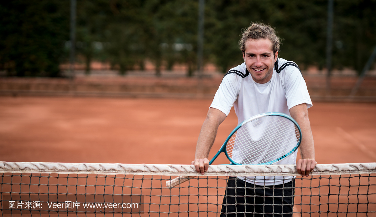 看着相机微笑的男性网球运动员的肖像