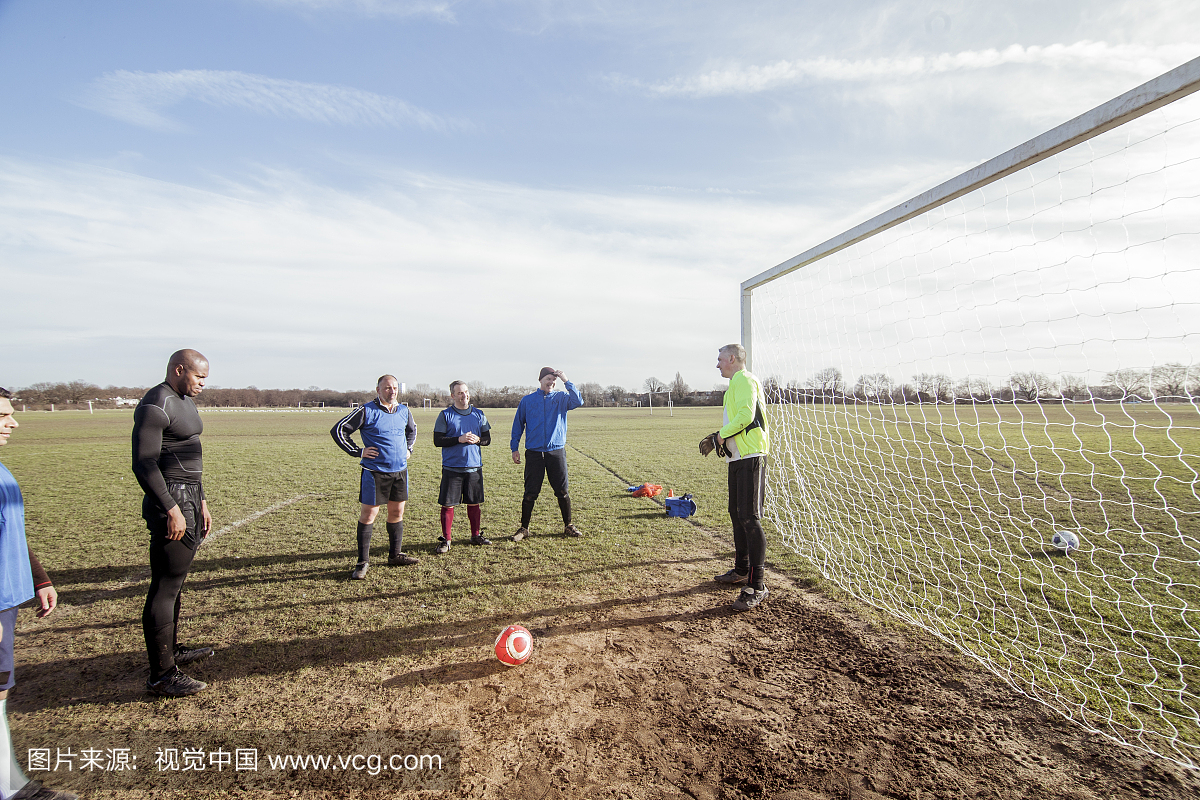成熟的男性足球运动员绑在球场上