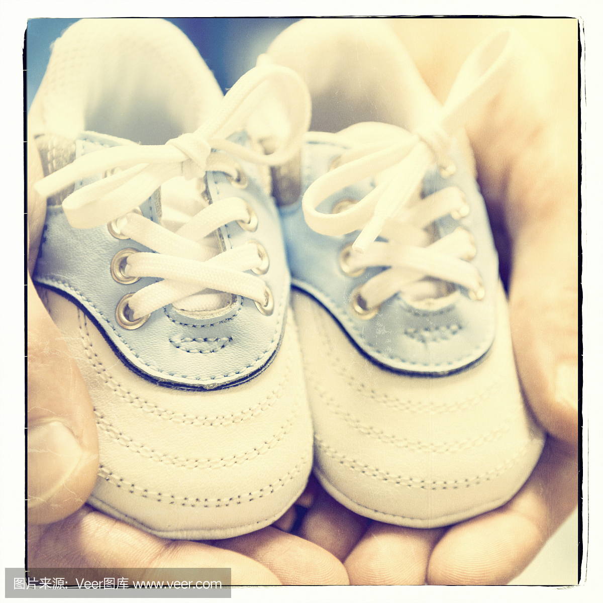 特写,可爱的新生婴儿鞋在父亲的手中,复古的样