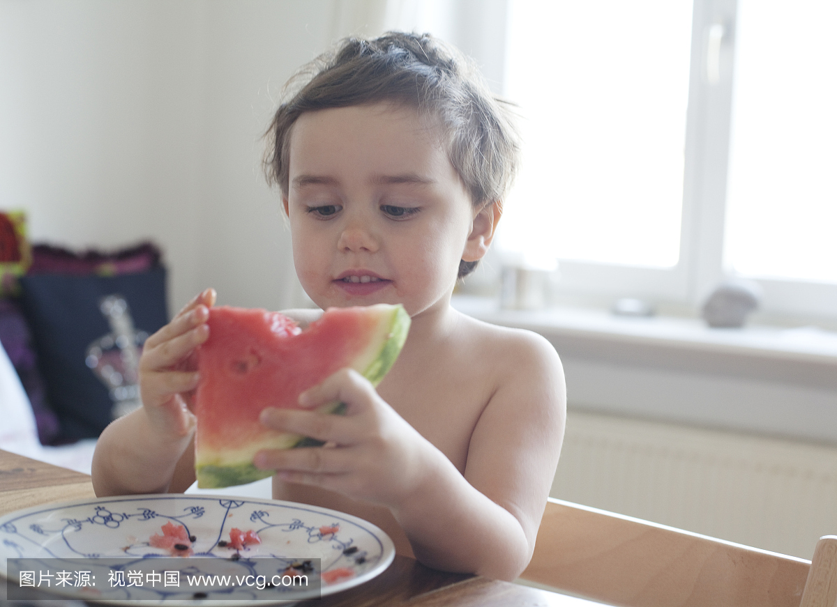 一个年轻的孩子在夏天吃西瓜