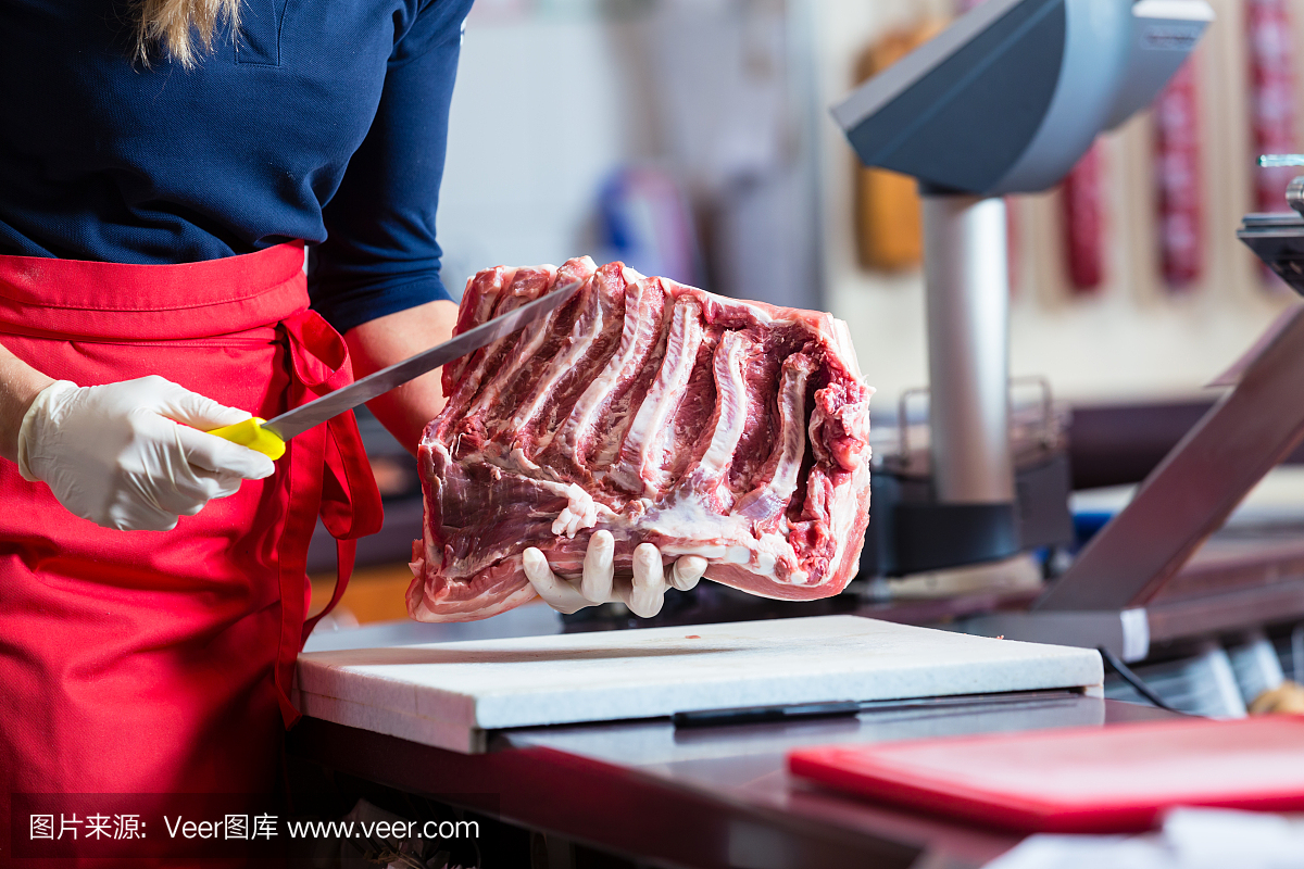 屠夫女人在她的店里切肋骨肉