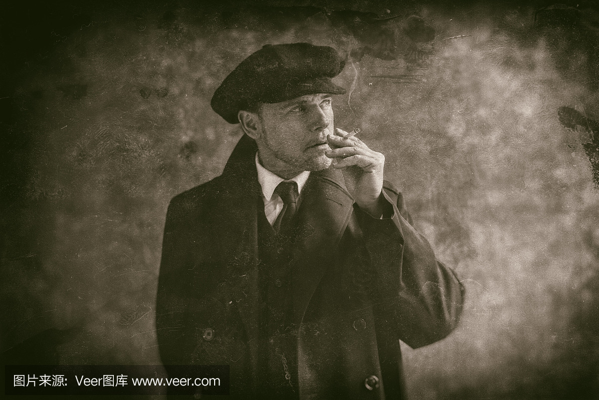 20世纪20年代英语流氓黑烟吸烟。穿黑色外套