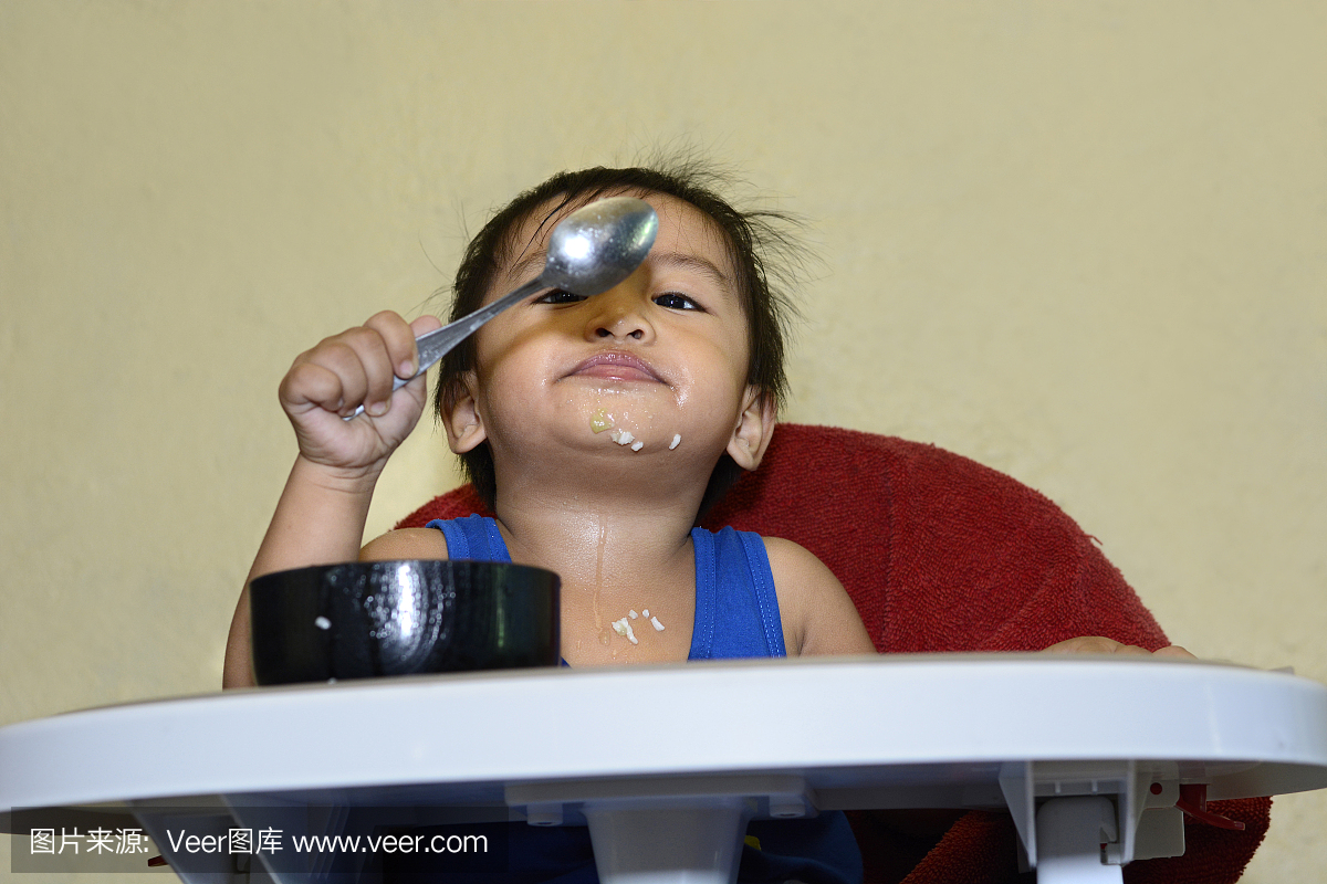 1岁的小男孩学会用勺子吃饭
