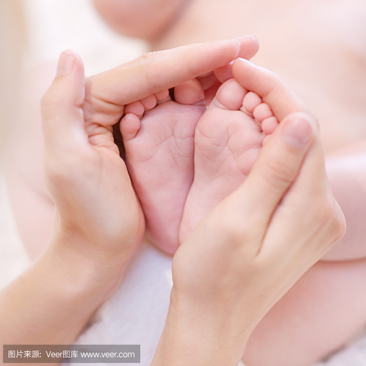 宝宝脚踩在母亲手中。