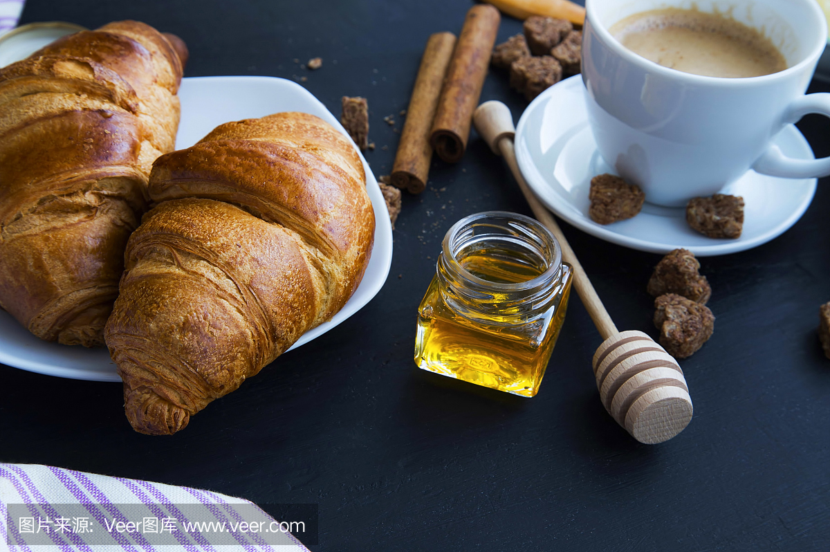 新鲜的羊角面包与蜂蜜罐和咖啡,早餐设置,选择