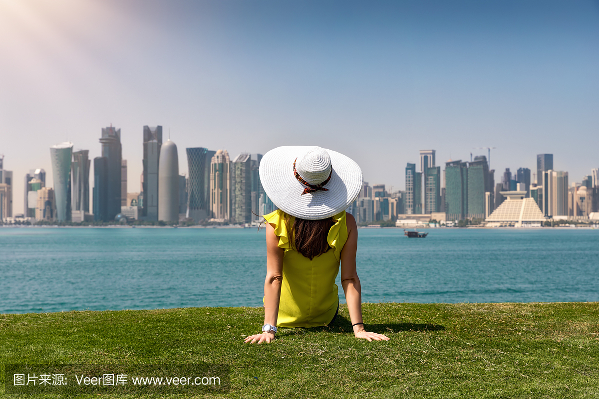 旅行者女人享有对多哈,卡塔尔的天际线的看法