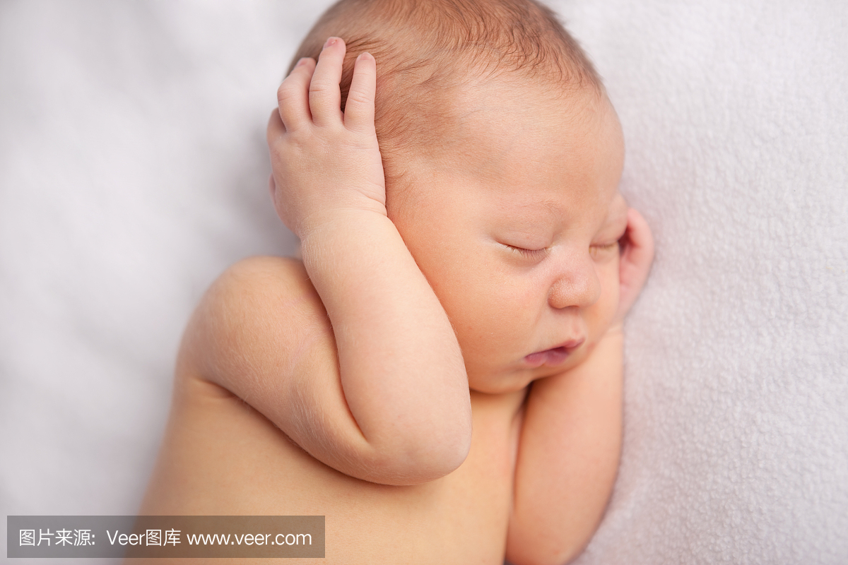 新生婴儿平静地睡在柔软的毯子上