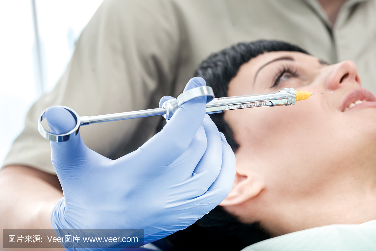 注射器与麻醉在特写镜头附近脸颊客户牙医。