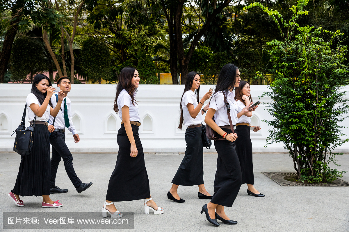 泰国学生穿制服参观寺庙区