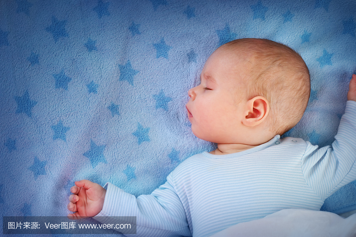 三个月大的宝宝睡在蓝色的毯子上