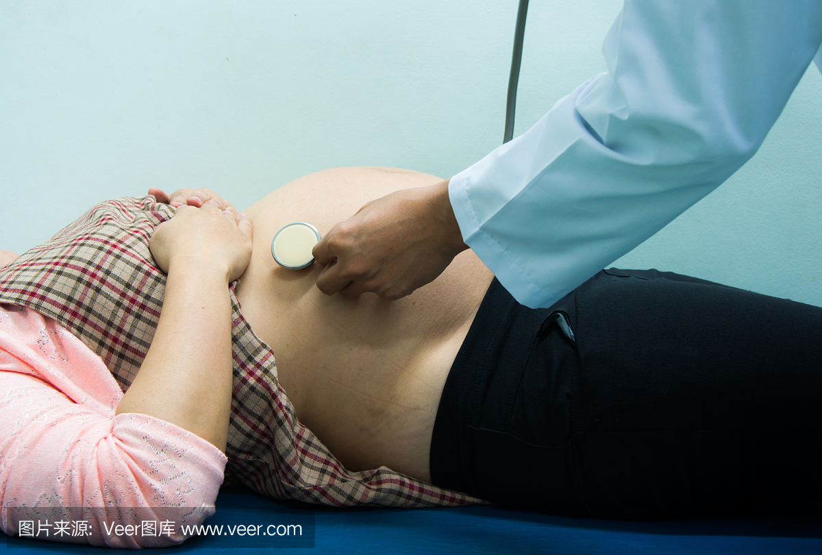 医生用听诊器检查怀孕妇女在医院。