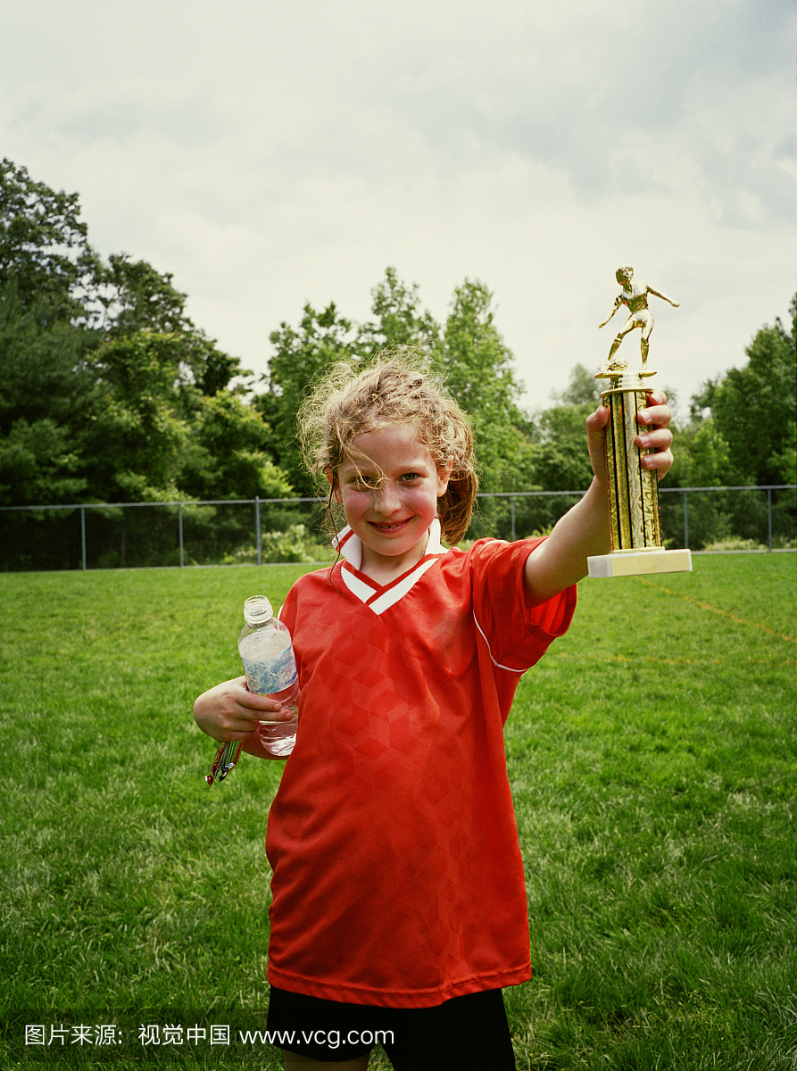 女孩(6-8)在现场,肖像举行足球奖杯