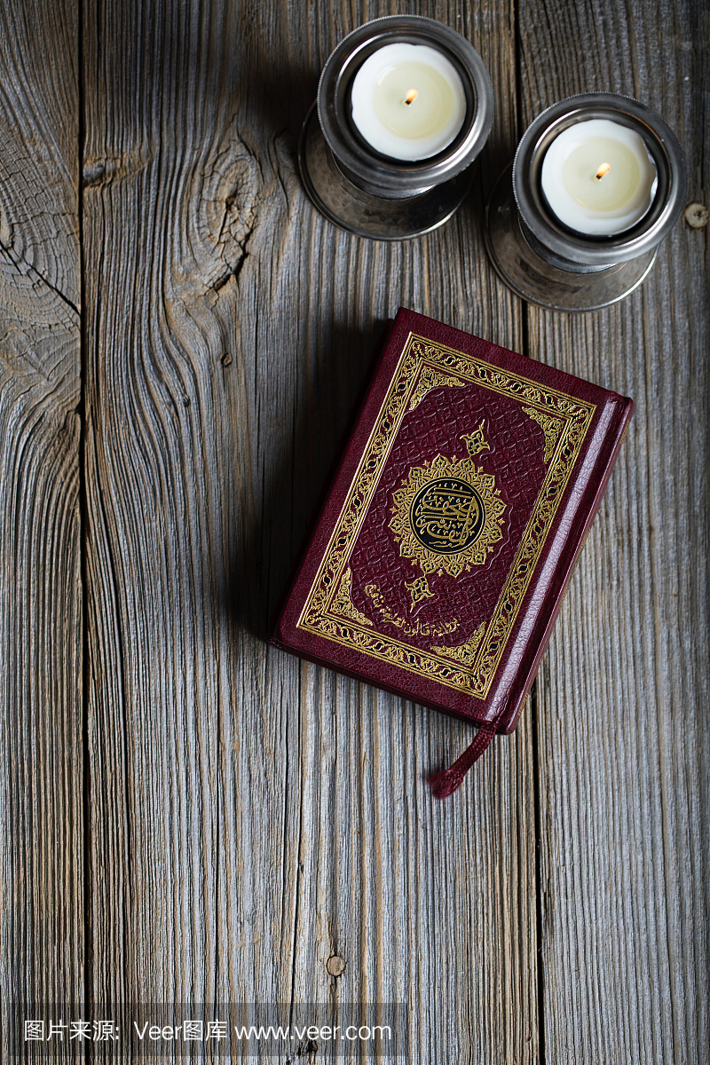 古兰经和木制表面上的蜡烛。翻译成英文 - 这本