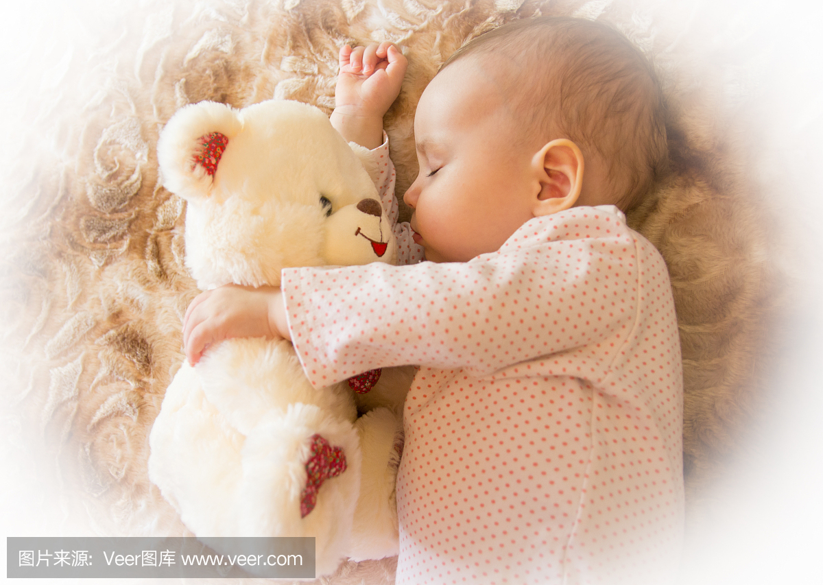 新生儿与玩具熊睡觉