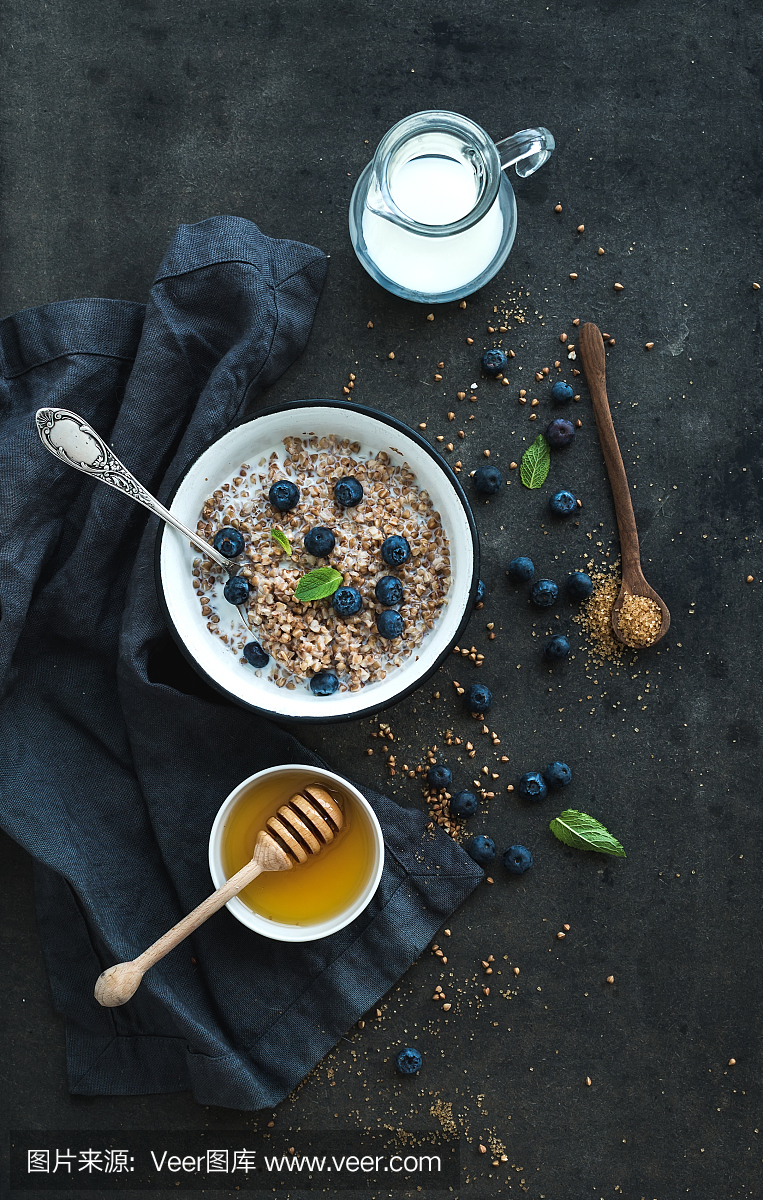 乡村健康早餐套餐。用牛奶,蓝莓煮熟的荞麦泥