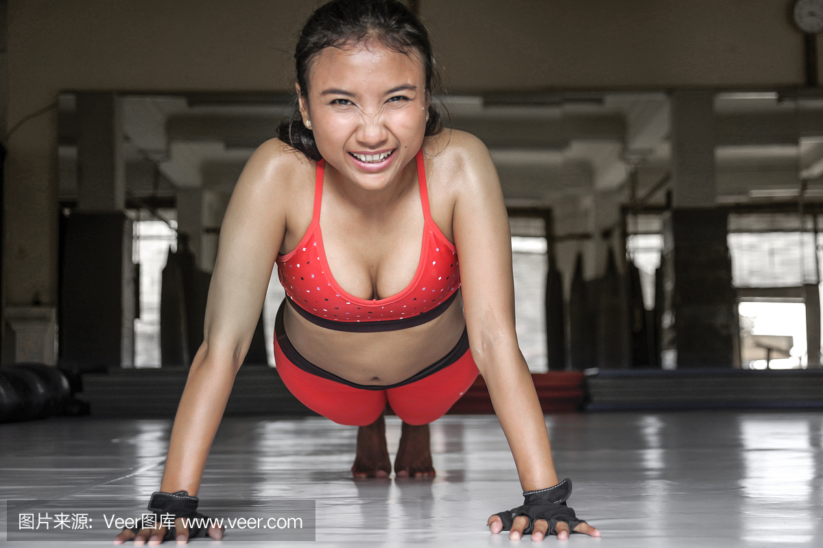 年轻快乐和性感出汗亚洲女子在运动服装做俯卧