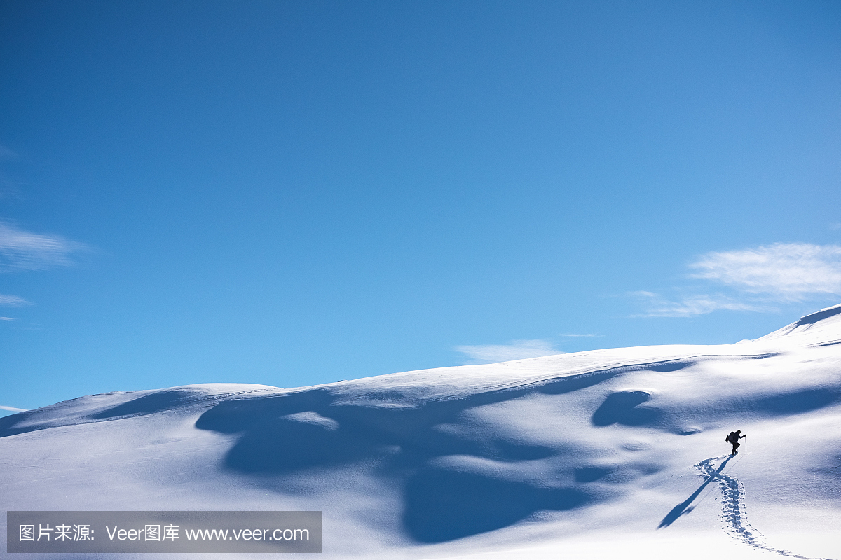 徒步旅行者走在多雪的山坡上
