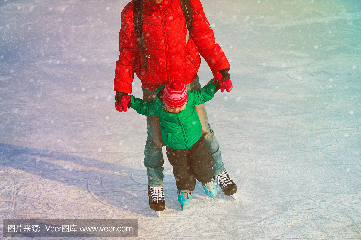 父亲和小女儿在冬天学习滑冰
