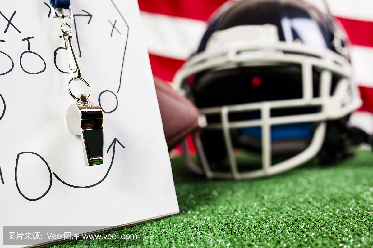 足球教练的口哨,足球,球员的头盔在绿草皮上。