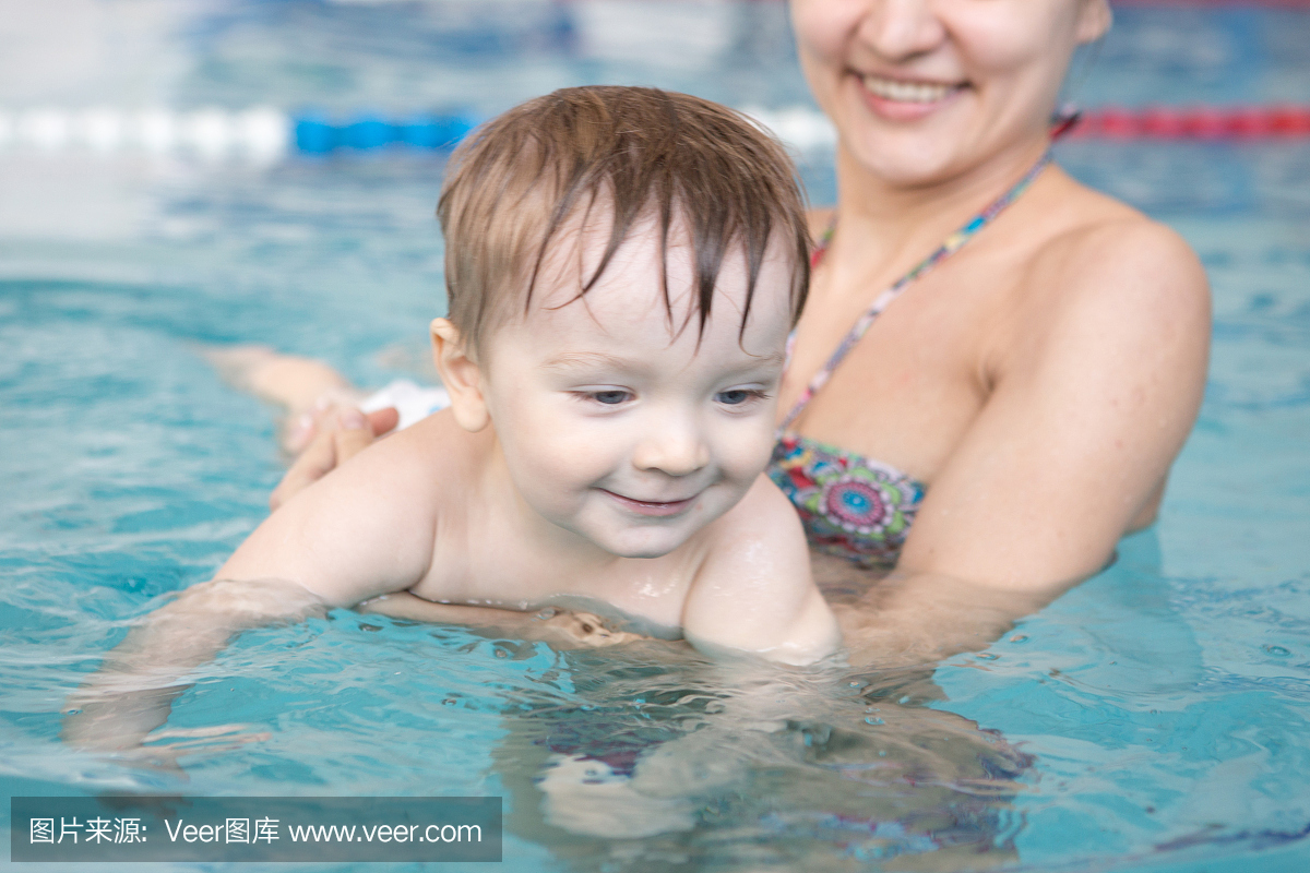 健康的家庭母亲教婴儿游泳池