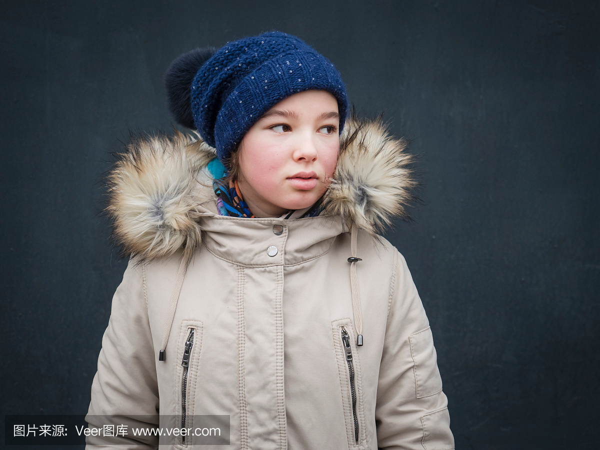 女孩在冬天期间戴编织帽子和皮大衣的特写镜头