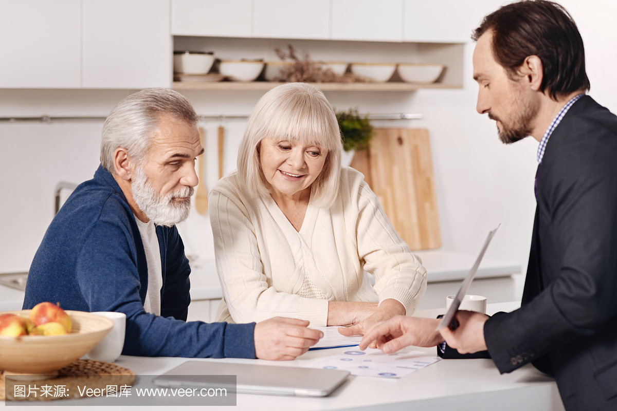自信的房地产代理人代表老年夫妇的房子