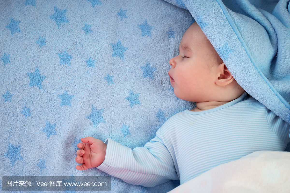 三个月大的宝宝睡在蓝色的毯子上