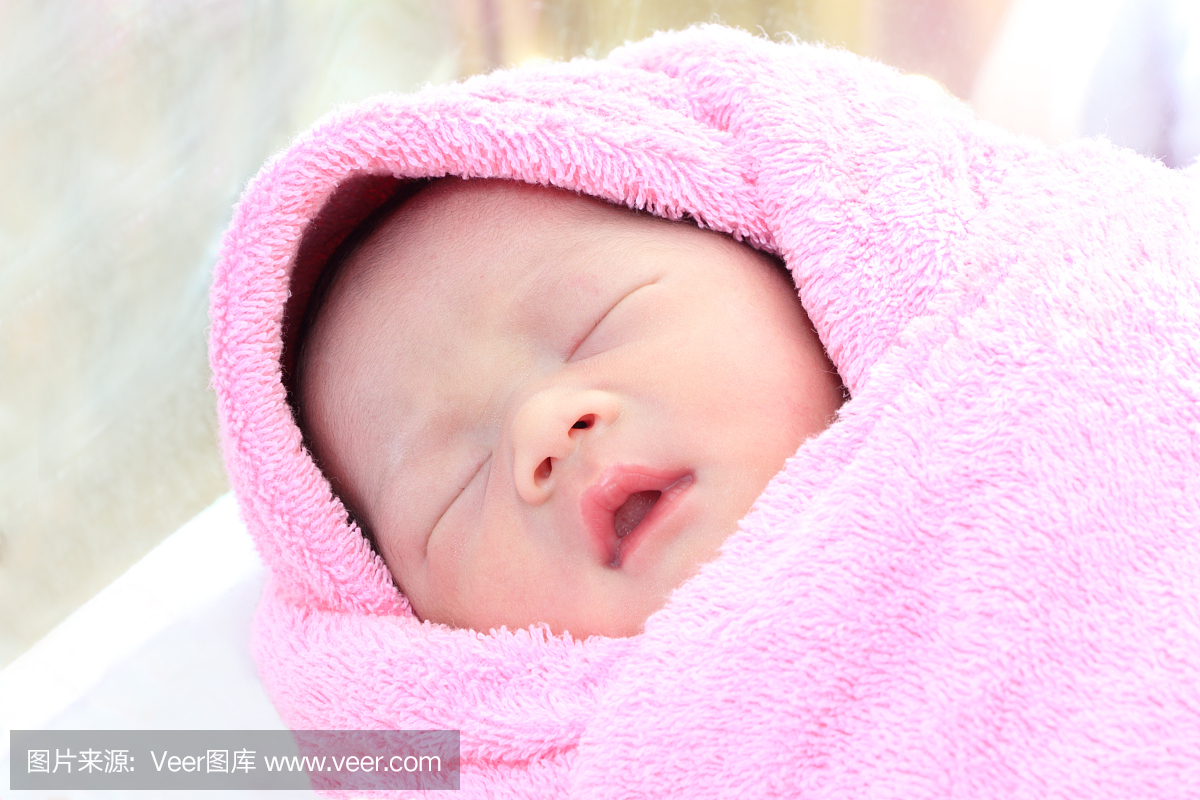 亚洲新生婴儿睡在毛巾上。