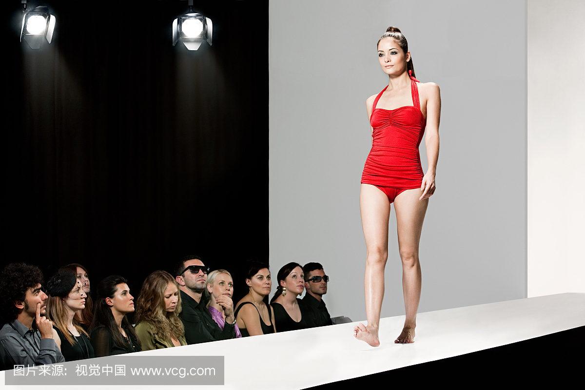 模特穿着红色泳衣在时装秀上的时装表演
