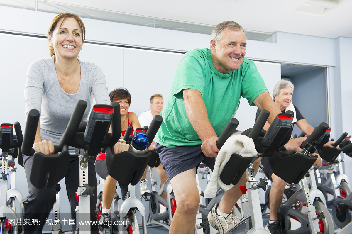 人们在健身房骑自行车
