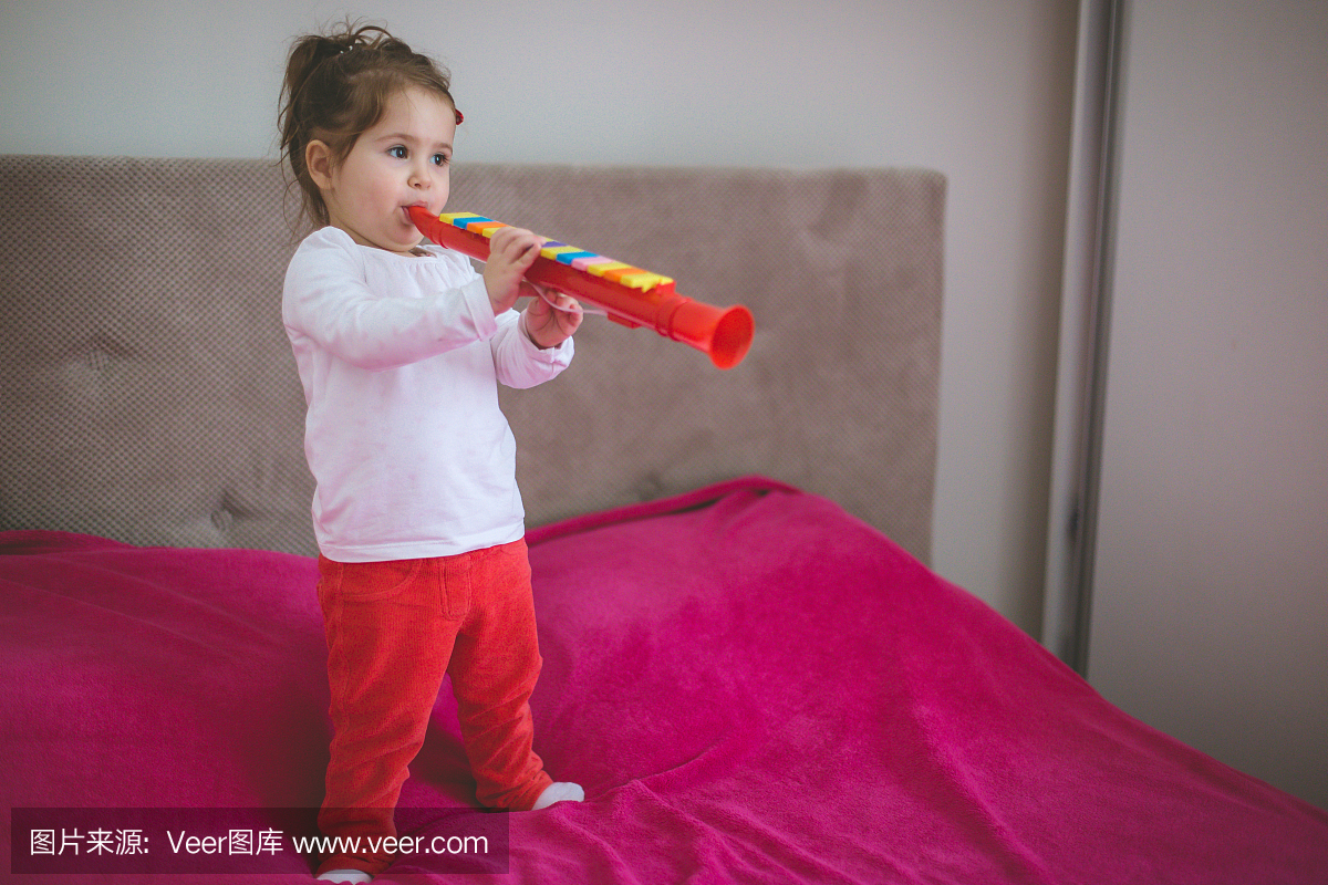 在卧室的女婴的音乐表演