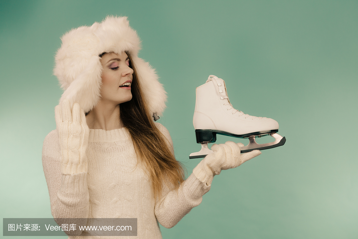 穿冬季帽子的女人看着溜冰鞋