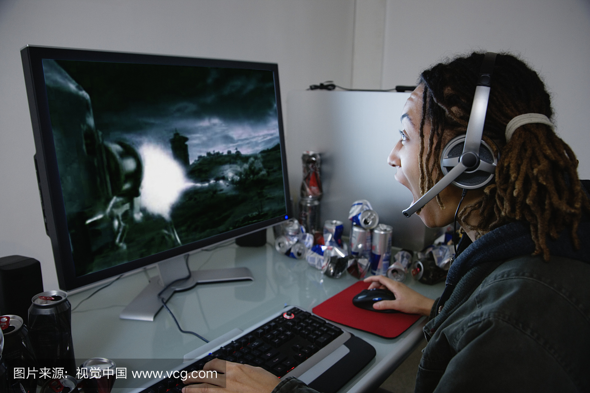 在电脑上玩电脑游戏的年轻女子,侧视图