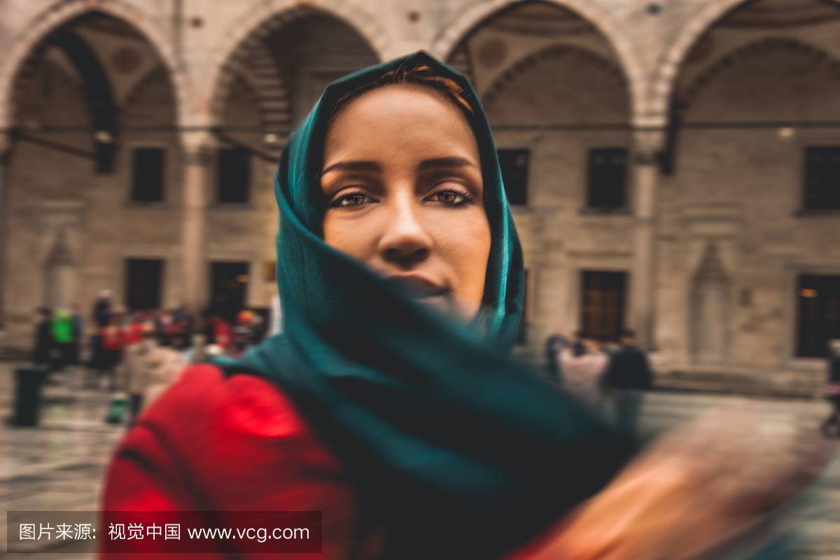 在清真寺前戴着头巾的女人肖像