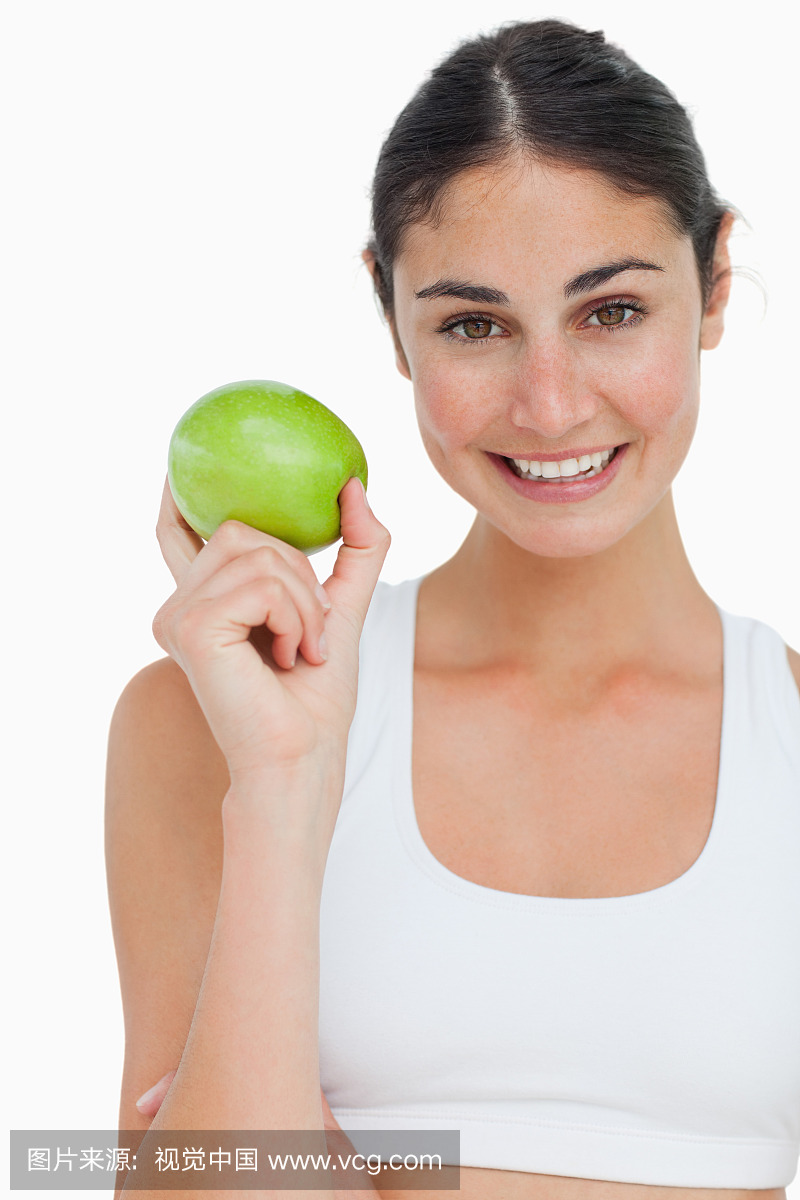 Close-up a brunette holding an green apple aga