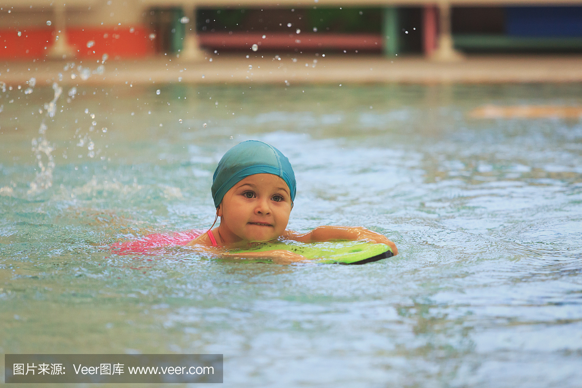 小女孩学会在游泳池里游泳