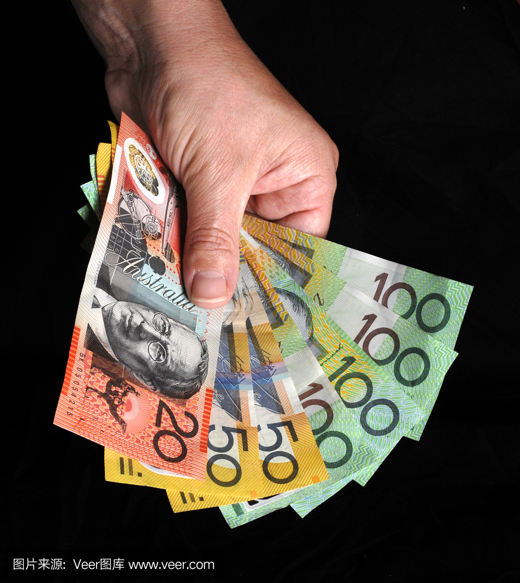 拿着澳大利亚货币的手拿着笔记