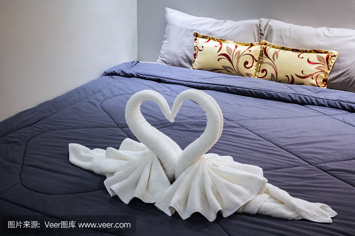 毛巾在床单上折叠成天鹅形状
