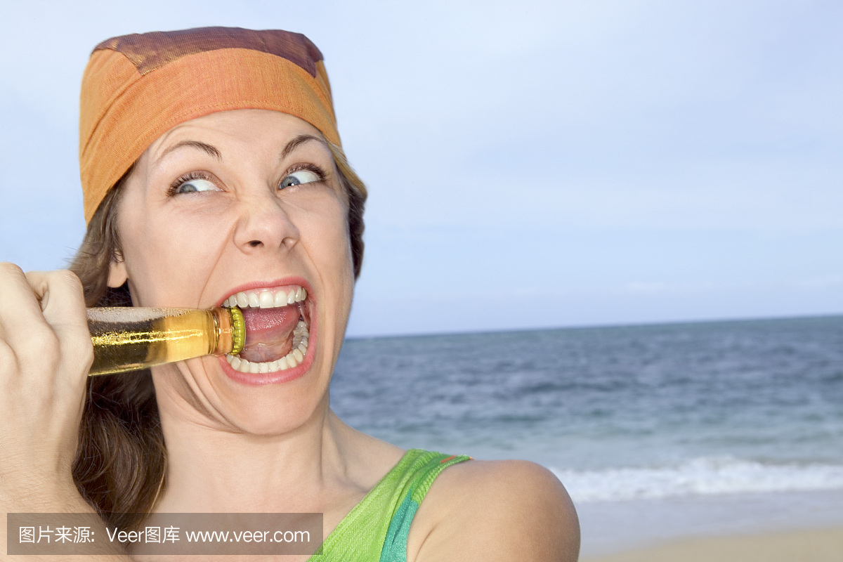 一个女人在海边咬一瓶瓶盖的肖像